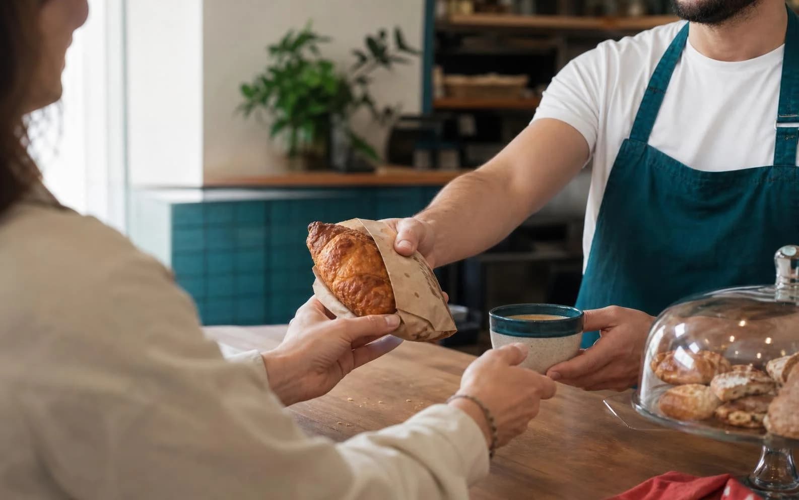 Un rezident primește un produs de patiserie de la o afacere din cartier